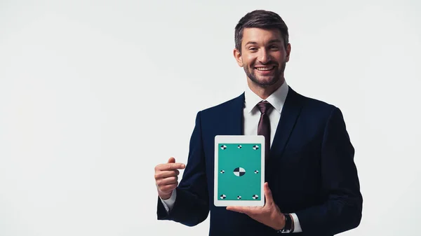 Homme d'affaires souriant pointant vers tablette numérique avec clé chromatique isolée sur blanc — Photo de stock