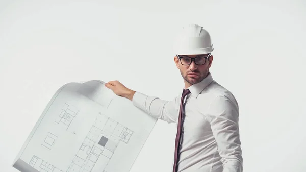 Architect in hardhat holding blueprint and looking at camera isolated on white — Stock Photo