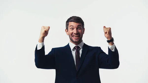 Excited businessman in suit looking at camera while showing yes gesture isolated on white — Stock Photo