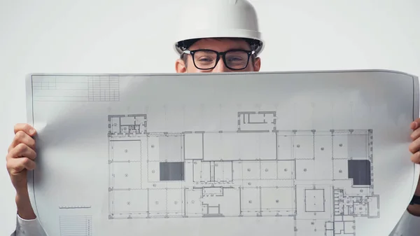 Plano en manos del arquitecto en gafas y casco aislados en blanco - foto de stock