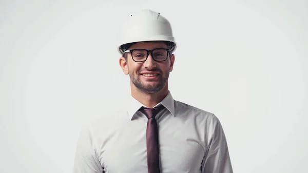 Alegre arquitecto en casco mirando a la cámara aislada en blanco - foto de stock