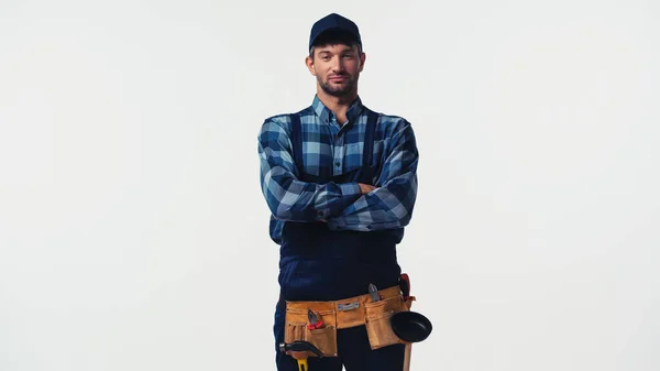 Homme à tout faire dans la ceinture à outils debout avec les bras croisés isolés sur blanc — Photo de stock