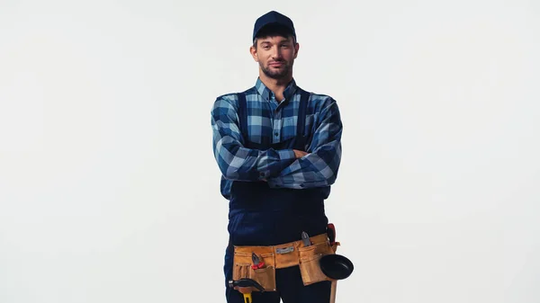 Handwerker im Werkzeuggürtel mit verschränkten Armen, isoliert auf weiß — Stockfoto