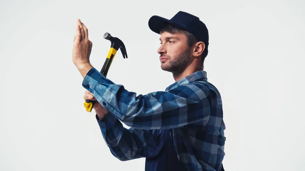 Handyman in cap tenuta martello isolato su bianco — Foto stock