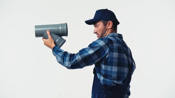 Seitenansicht des Klempners Blick auf Kunststoffrohr isoliert auf weiß — Stockfoto
