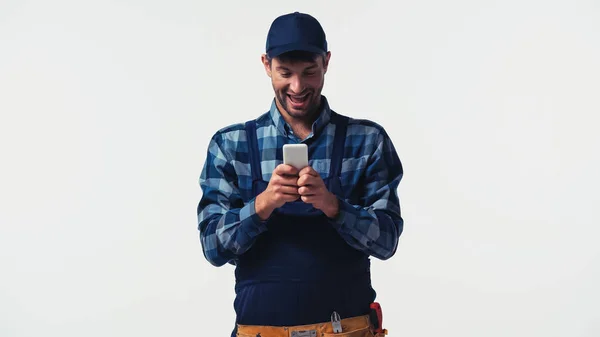 Handyman positivo usando smartphone isolado no branco — Fotografia de Stock