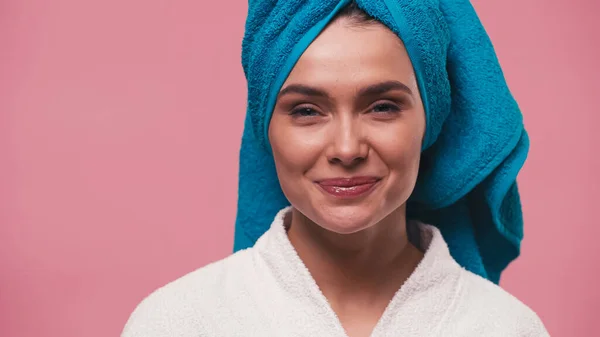 Mulher feliz com pele perfeita e toalha na cabeça olhando para a câmera isolada em rosa — Stock Photo