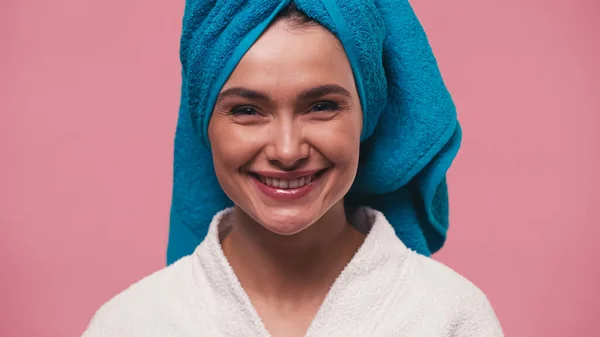 Femme heureuse avec serviette bleue sur la tête regardant la caméra isolée sur rose — Photo de stock