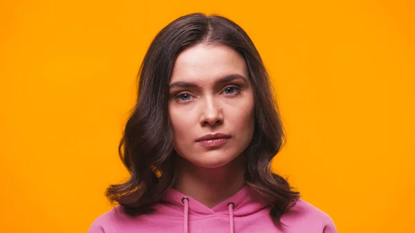 Young and calm woman looking at camera isolated on yellow — Stock Photo