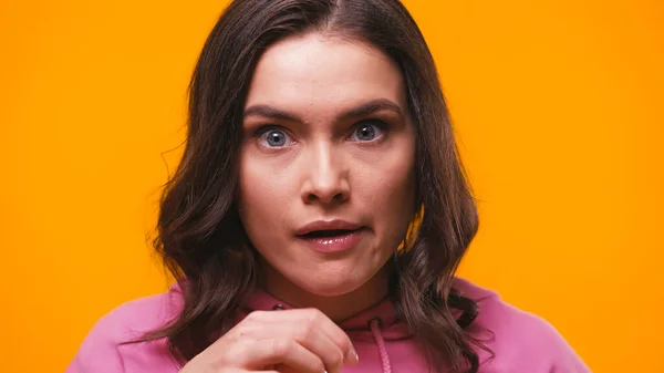 Impressed brunette woman looking at camera isolated on yellow — Stock Photo