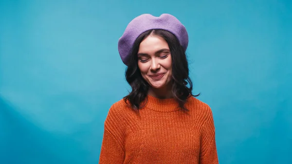 Femme timide en pull lilas et pull orange souriant isolé sur bleu — Photo de stock