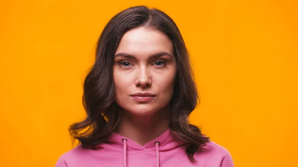 Young confident woman looking at camera isolated on yellow — Stock Photo