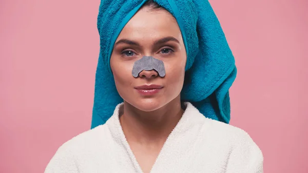 Woman with blue towel on head and cleansing nose patch looking at camera isolated on pink — Stock Photo