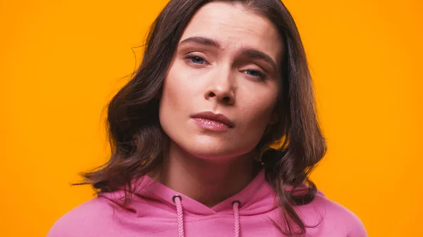 Skeptical and haughty woman looking at camera isolated on yellow — Stock Photo