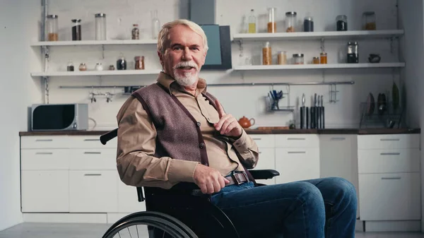 Pensionista discapacitado hablando mientras está sentado en silla de ruedas - foto de stock