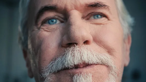 Крупним планом веселий пенсіонер з блакитними очима — стокове фото