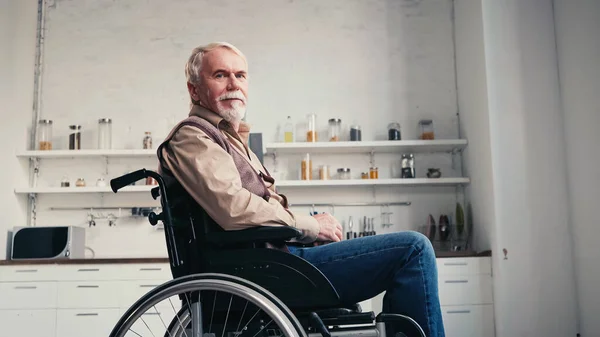Homem aposentado barbudo em cadeira de rodas olhando para a câmera — Fotografia de Stock