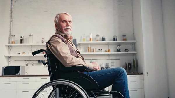 Bearded retired man in wheelchair looking at camera — Stock Photo