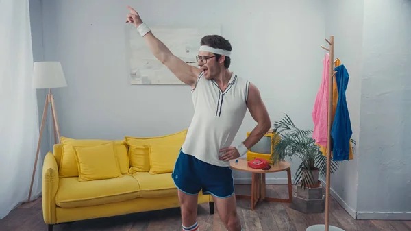 Енергійний спортсмен з рукою на танець стегна у вітальні — стокове фото