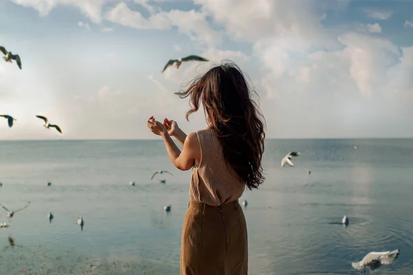 Güzel Asyalı Kadın Deniz kenarında martılarla poz veriyor.