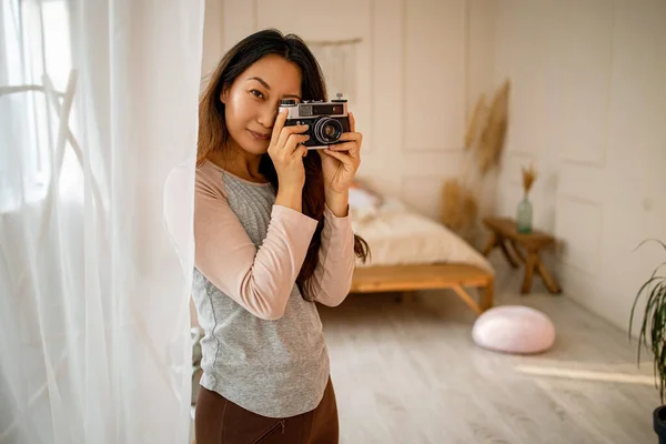 Beautiful Asian Woman With Vintage Photo Camera in a bright room