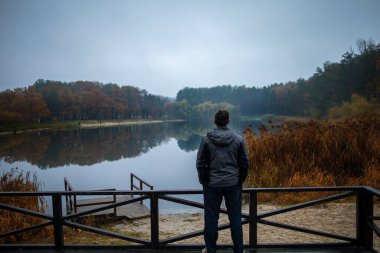 Bir adam tek başına dikiliyor, uzaklara bakıyor, derin düşüncelere dalmış..