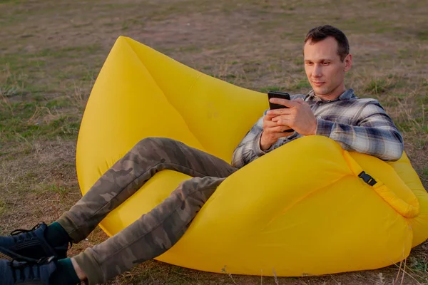 Hombre Sentado Una Silla Inflable Naturaleza Usando Smartphone —  Fotos de Stock