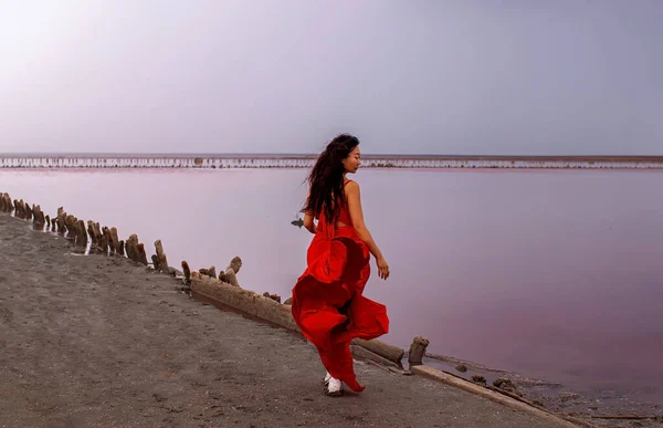 Kırmızı Ipeksi Elbiseli Zarif Kadın Gün Batımında Tuz Gölü Kenarında — Stok fotoğraf