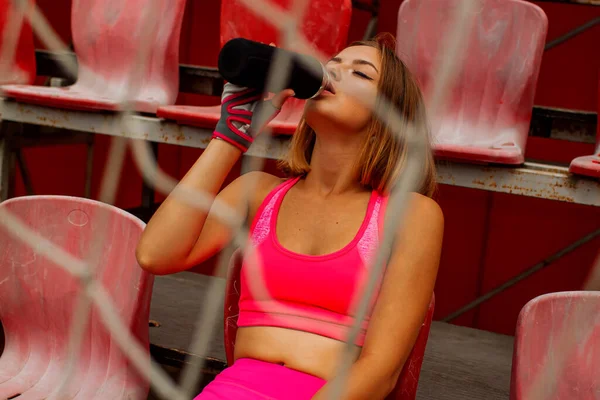 Spor eğitiminden sonra dinlenin. Pembe Pozisyonlu Güzel Spor Kızı