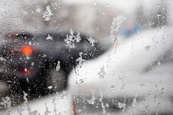 Cama Damlalar. Yağmur ve ıslak kar yağarken arabanın penceresinden görüntü.