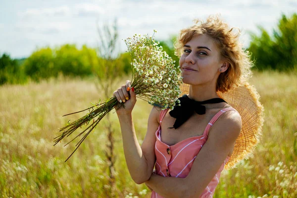 夏天的田野里 白种人穿着卷曲的头发 欣赏野花 — 图库照片