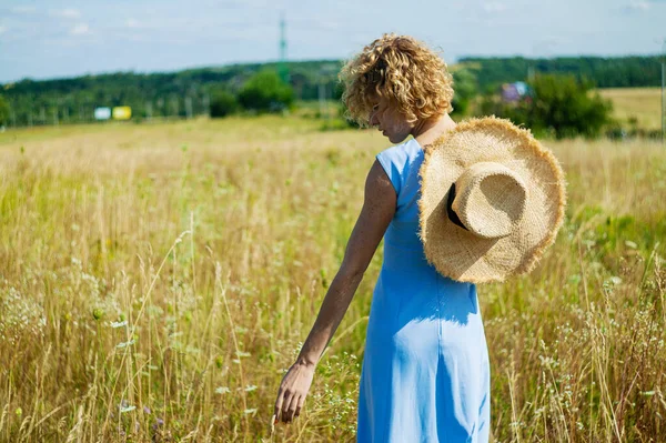 夏天的田野里 白种人穿着卷曲的头发 欣赏野花 — 图库照片