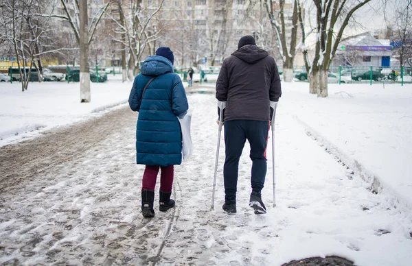 Mann Läuft Mit Gebrochenem Bein Auf Krücken Durch Winterstraße — Stockfoto