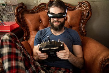 Çekici beyaz adam Joystick 'i tutuyor ve sanal gerçeklik gözlüğü takıyor.
