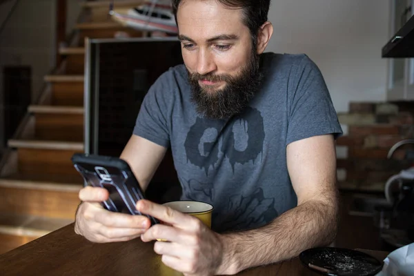 Hombre Usando Teléfono Móvil Mientras Toma Una Taza Café Casa —  Fotos de Stock