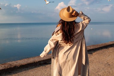 Güzel Asyalı Kadın Deniz kenarında martılarla poz veriyor.