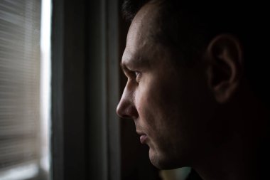 Pencereden dışarı bakan üzgün adamın portresi