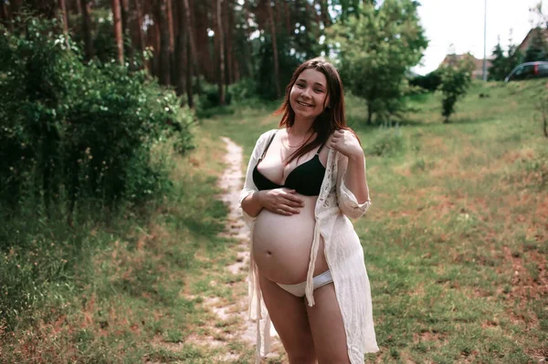 美丽柔嫩的孕妇站在绿草上 看着相机 — 图库照片