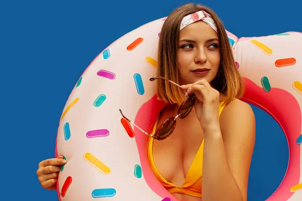 Νεαρή Γυναίκα Ποζάρει Donut Shaped Κολυμπήστε Φουσκωτό Δαχτυλίδι Απομονώνονται Μπλε — Φωτογραφία Αρχείου