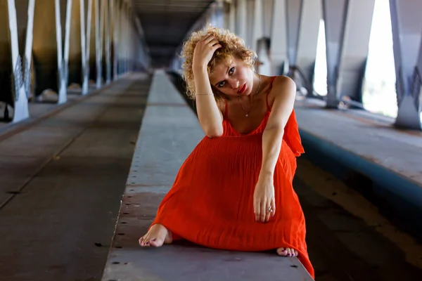 Прекрасна Блондинка Кучерявим Волоссям Червоному Одязі Під Старим Мостом — стокове фото