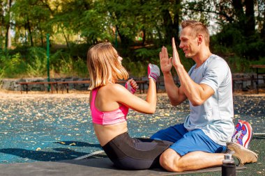 Şehir parkında egzersiz yapan genç ve tatlı bir çift. Açık hava sporu