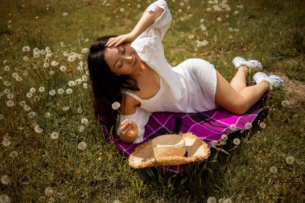 年轻美丽的亚洲女人在夏天的田野里 捧着一束蒲公英在草地上飘扬 — 图库照片