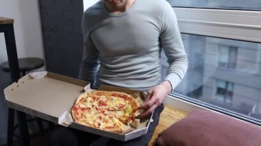 Mutlu beyaz adam evde pizza yiyor..