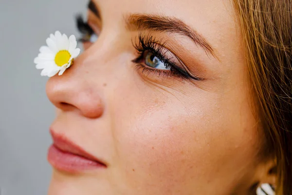 Skin Care And Women Beauty. Nature Beauty Portrait Of A Girl With Chamomile On Face.