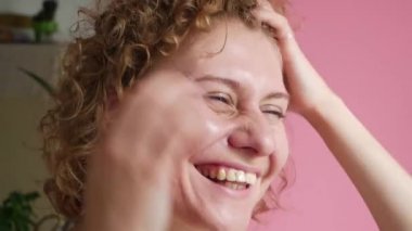 Gülümseyen ve gülen sevimli genç bir kadın. 