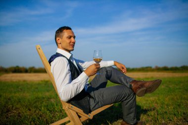 İyi giyimli bir adam şarap tadıyor.