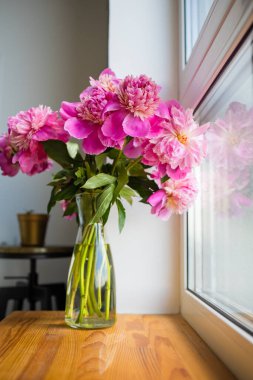 Pencerede duran pembe şakayık demeti manzarası..