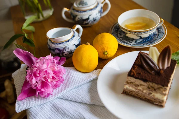 Fatia Sobremesa Bolo Chocolate Flores Xícara Chá Com Limão Mesa — Fotografia de Stock