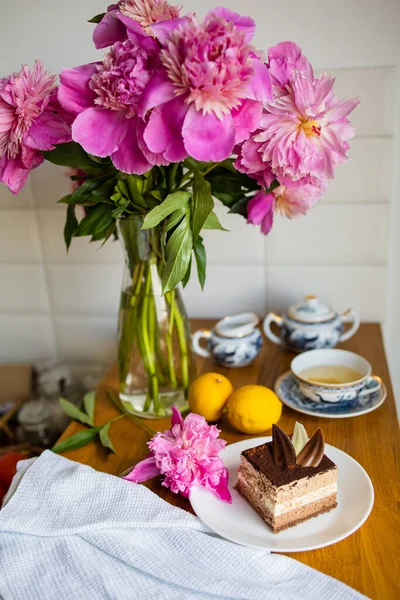Slice Of Chocolate Cake Dessert, Flowers, Cup Of Tea With Lemon On Table