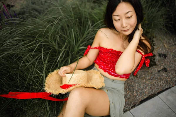 亚洲女人躺在草地上开心地朝旁边看去 — 图库照片